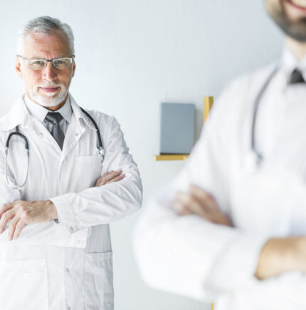 elderly-doctor-standing-anonymous-colleague (1)